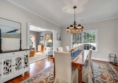 Long dining room table, fancy lighting sneak peak view of living area real estate photo Cromwell, CT
