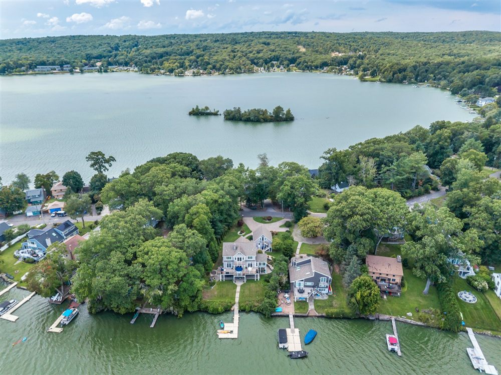 Aerial view of lakeside homes, docks and wooded islands showing the surrounding waterfront setting